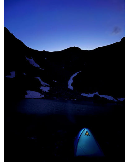 Tente 3 personnes Isis 3, marque Freetime, vue de nuit au bord d'un lac de montagne de la vallée Aktru, avec lumière allumée dans la tente bleue.
Crédit @kiryanova_sveta