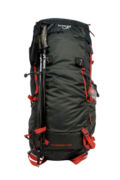 Sac de montagne Everest 80, génération 2.0, capacité 80 litres, gris foncé et sangles rouges, traitement hydrophobe sans PFAS, vue de face, avec bâtons de marches attachés dans les porte-bâtons