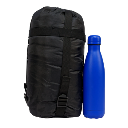 Sac de couchage été Litetech 125, marque Freetime, duvet température confort 12°C pour 1kg — vue dans son sac de transport à côté d'une gourde de 500 ml (photo détourée)