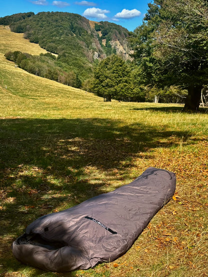 Sac de couchage Lodenn, marque Freetime, duvet température confort -1°C pour moins de 1kg ! vu posé sur l'herbe et les feuilles d'automne dans une clairière