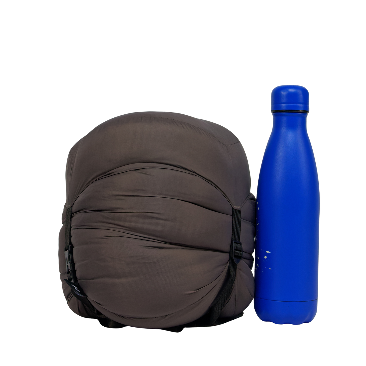Sac de couchage Lodenn, marque Freetime, duvet température confort -1°C pour moins de 1kg ! vue compressé au maximum à côté d'une gourde de 500 ml (photo détourée)